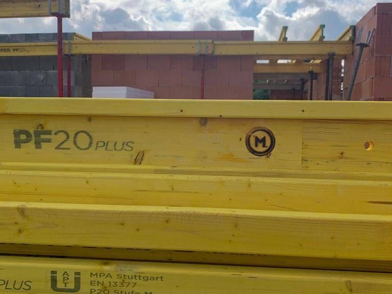 Gestapelte gelbe Schalungsträger aus Holz auf der Baustelle
